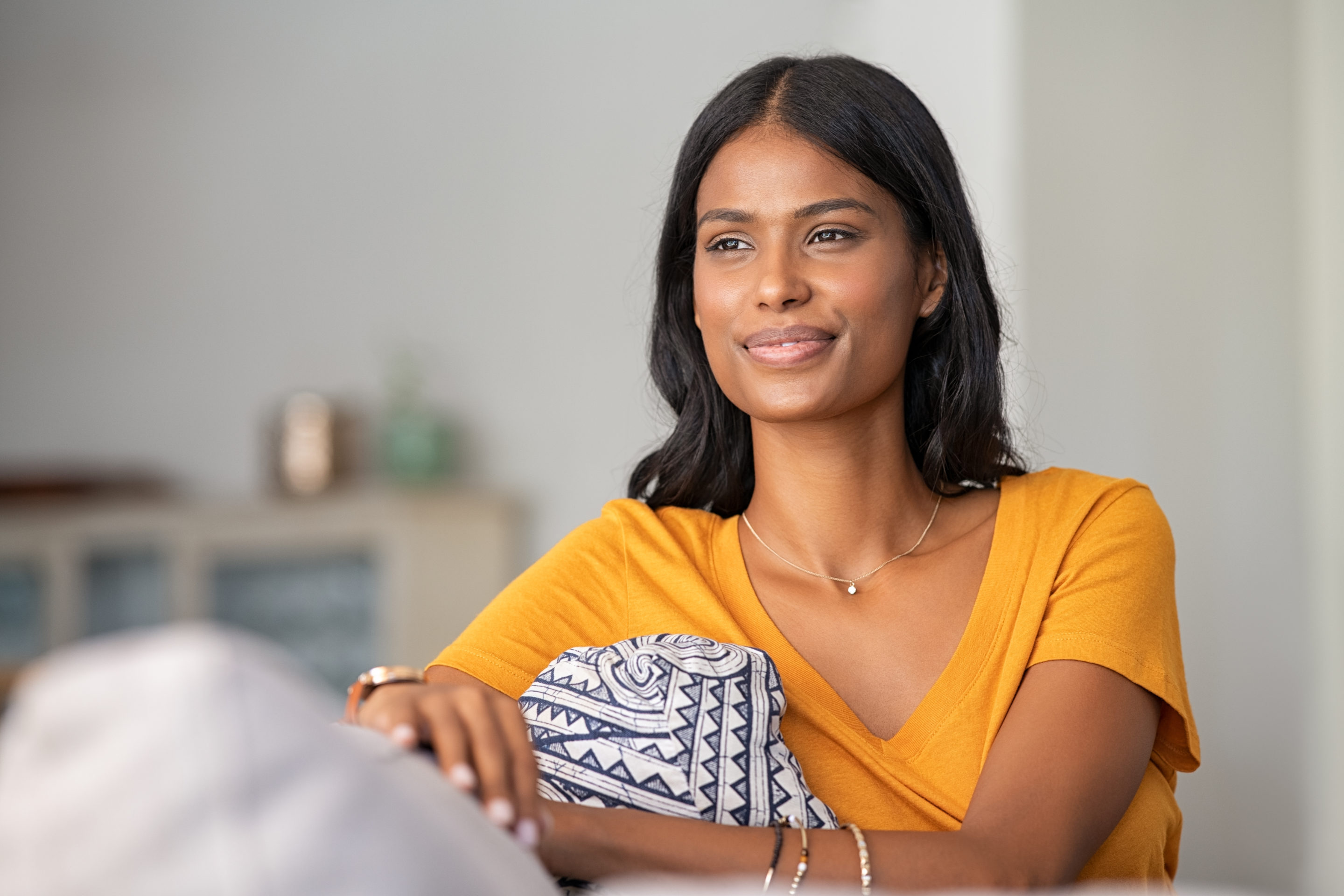 Young,Indian,Woman,Relaxing,On,Couch,At,Home,While,Looking
