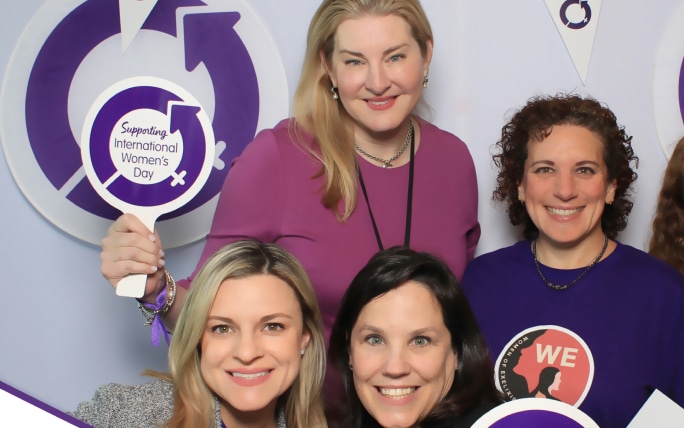 Four female employees posing at community event