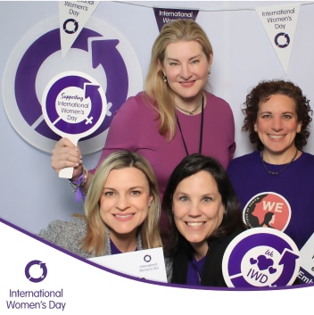 Four female employees posing at community event