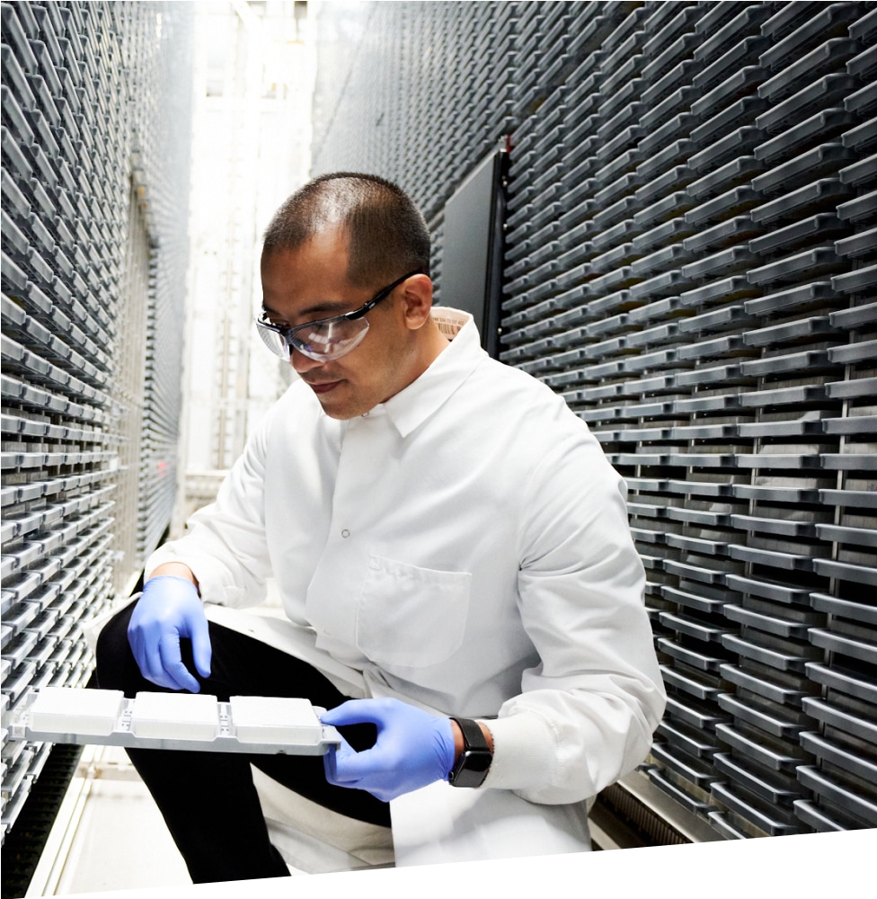 Male scientist in oncology lab kneeling down with sample