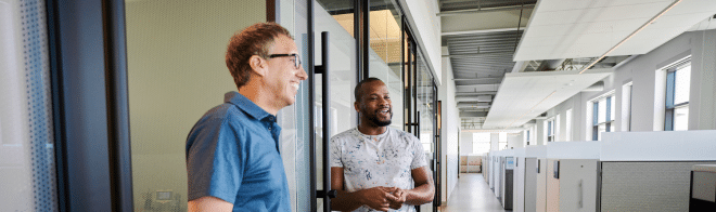 Two diverse men talking in hallway