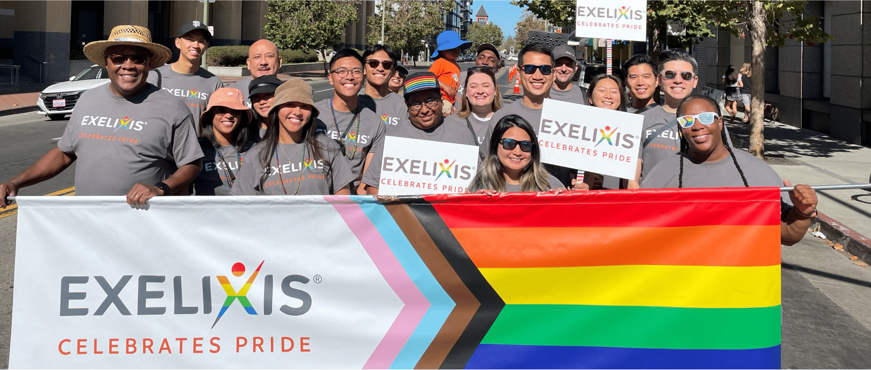 Committed to DEI Employees holding pride celebration flag in parade