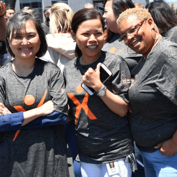 Three female Exelixis employees smiling at volunteer event