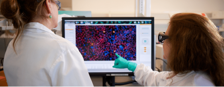 Two scientists reviewing data on a computer screen