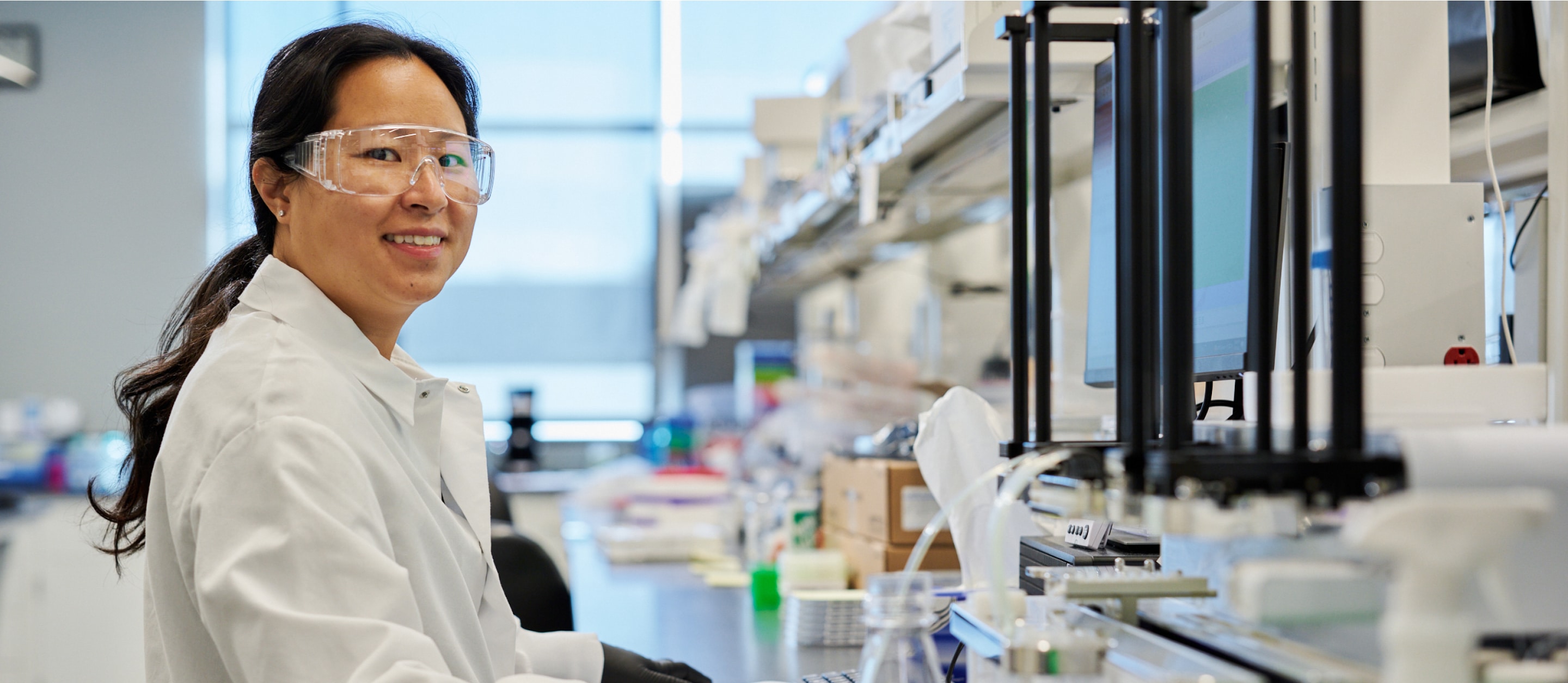 Female scientist in lab smiling at camera