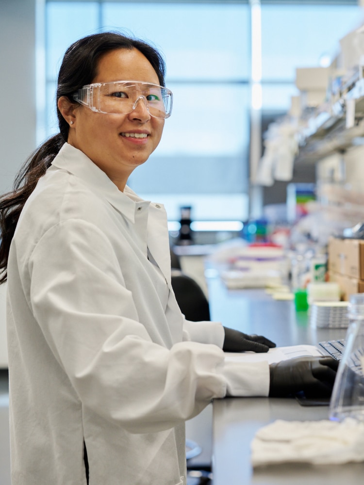 Female scientist in lab smiling at camera