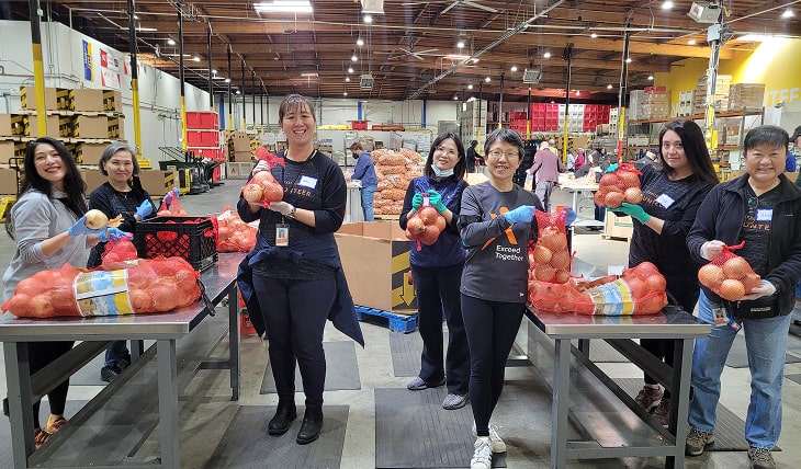 Exelixis employees volunteering at a food bank, packing onions.